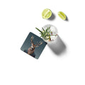 Garnished cocktail with lime wedges and a coaster featuring a deer on a white background